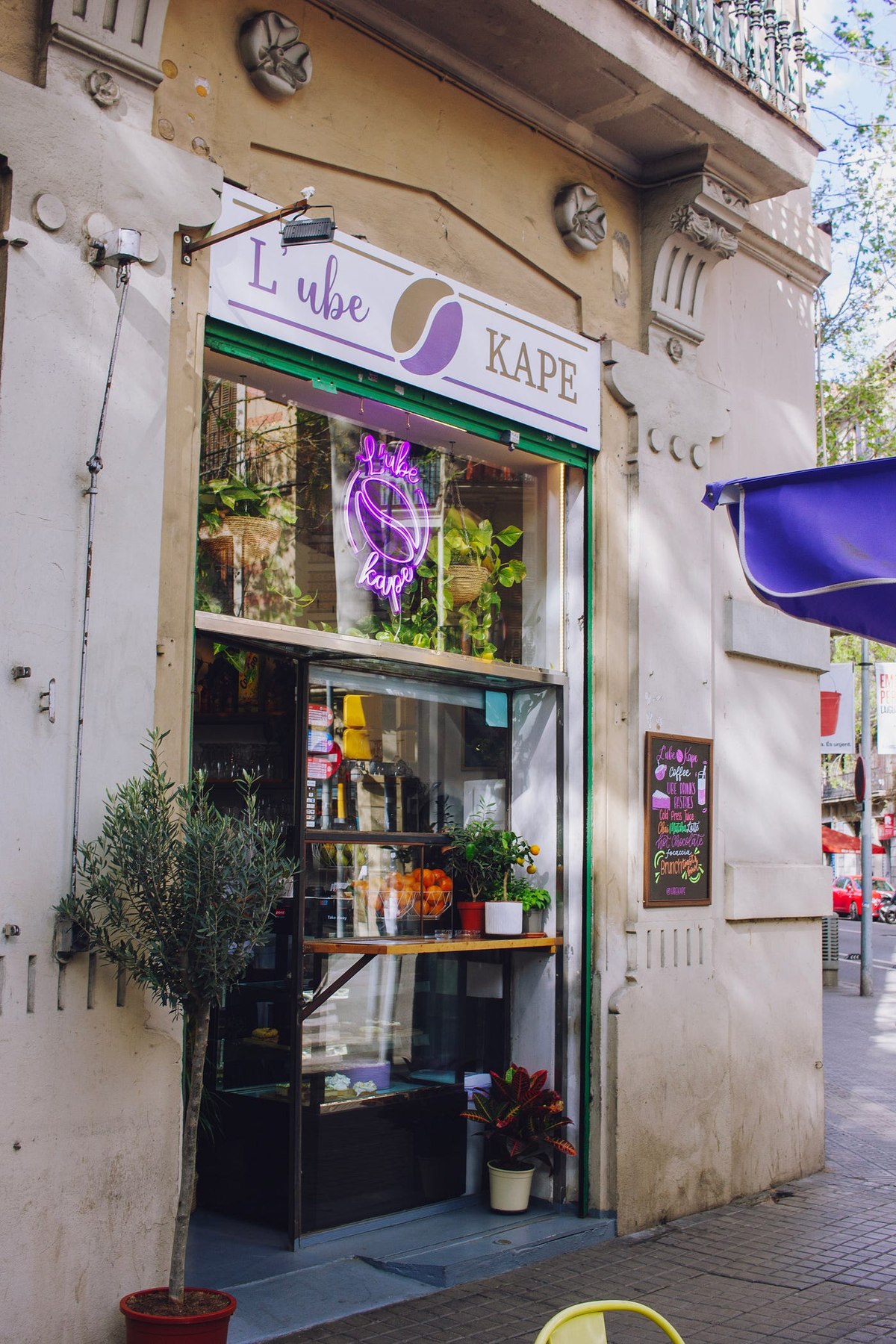 The purple L’Ube Kape sign and café entrance in Barcelona